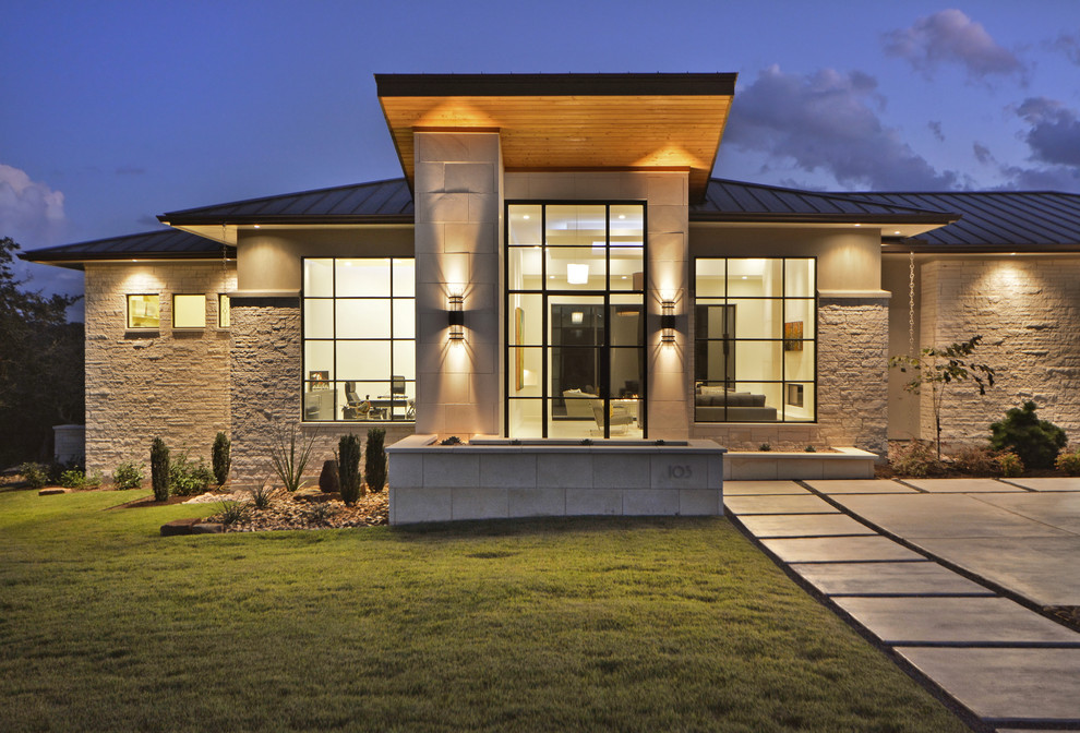 Design ideas for a contemporary one-storey beige exterior in Austin with stone veneer and a hip roof.