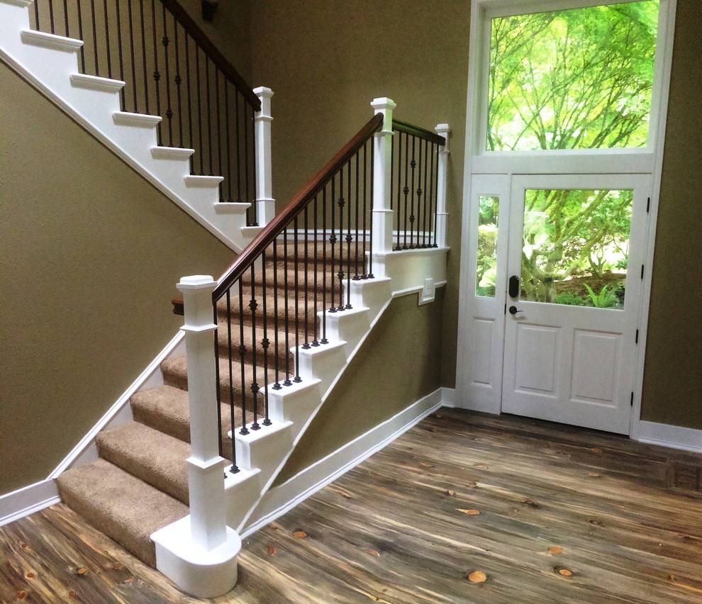 Photo of a mid-sized country wood u-shaped staircase in Portland with carpet risers and wood railing.