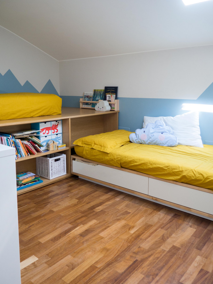 This is an example of a medium sized eclectic children’s room for boys in Other with white walls, dark hardwood flooring and wainscoting.