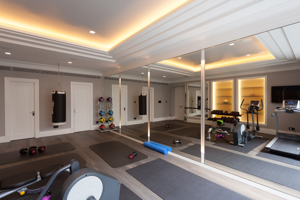 Inspiration for a transitional multipurpose gym in London with beige walls, light hardwood floors and grey floor.