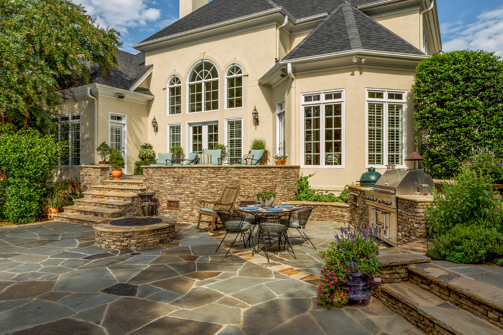 Inspiration for a mid-sized traditional backyard patio in Charlotte with a fire feature, natural stone pavers and no cover.