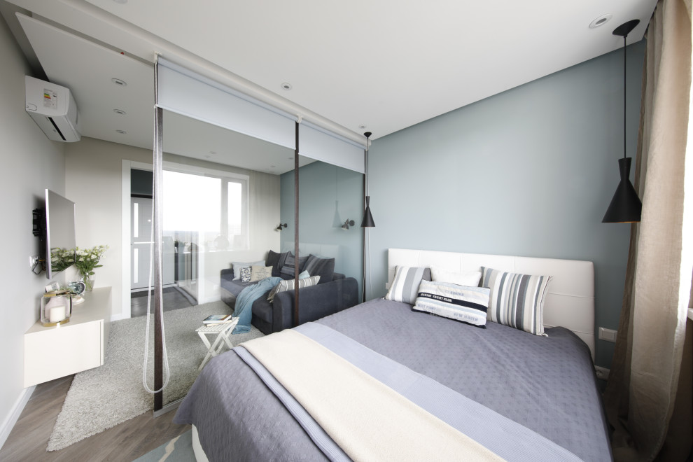 Small contemporary master bedroom in Moscow with blue walls, laminate floors and beige floors.