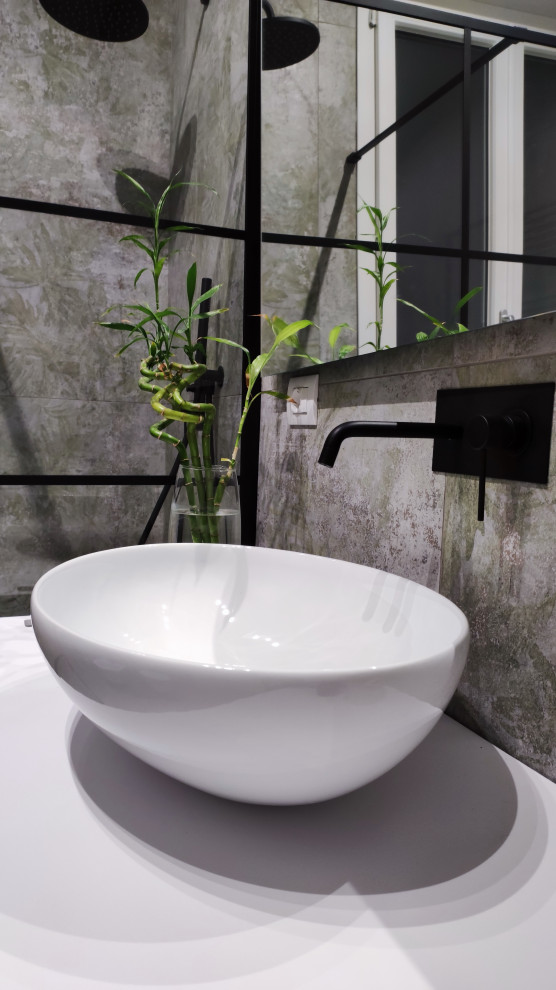 Inspiration för ett mellanstort industriellt vit vitt badrum med dusch, med släta luckor, vita skåp, en kantlös dusch, en vägghängd toalettstol, flerfärgad kakel, porslinskakel, klinkergolv i porslin, ett fristående handfat och grått golv