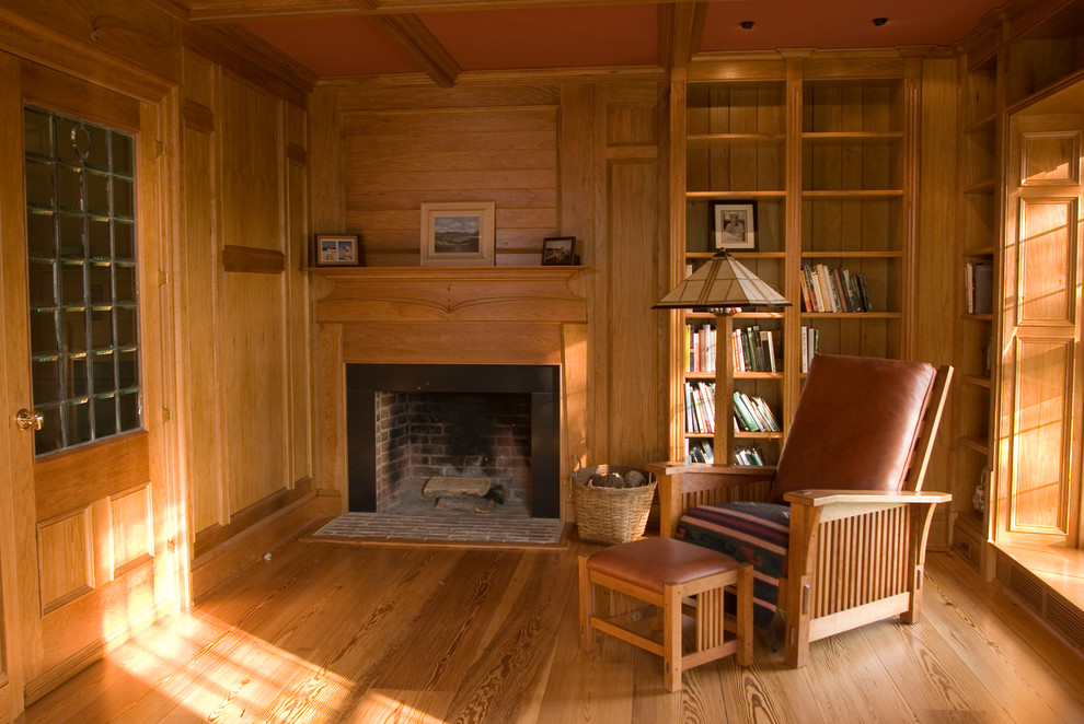 Small midcentury enclosed living room in Richmond with a library, brown walls, light hardwood floors, a standard fireplace and a wood fireplace surround.