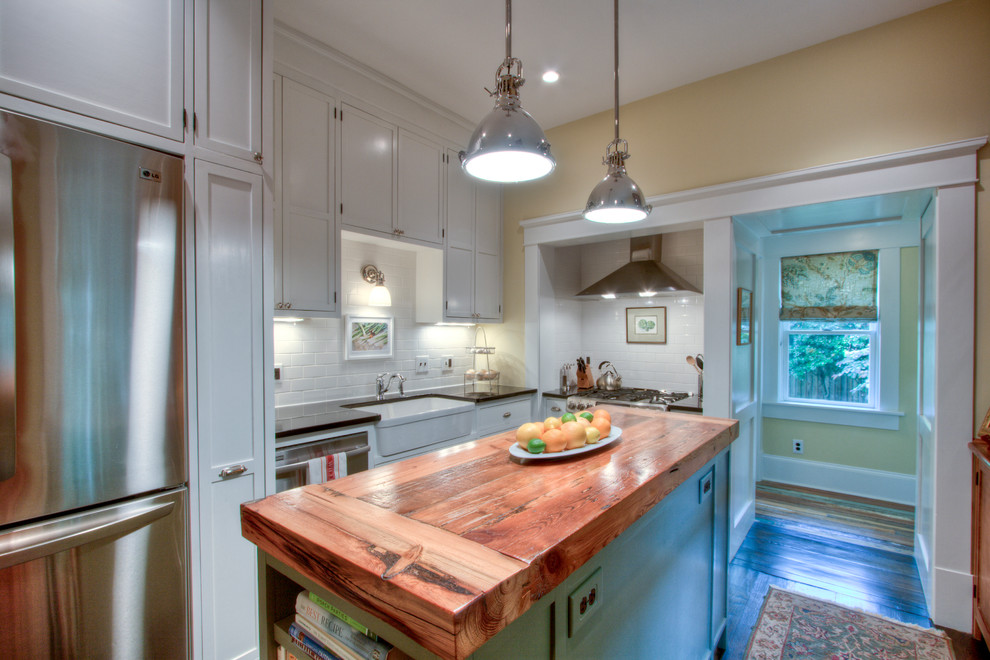 Inspiration for an arts and crafts l-shaped separate kitchen in Atlanta with a farmhouse sink, recessed-panel cabinets, white cabinets, granite benchtops, white splashback, subway tile splashback and stainless steel appliances.
