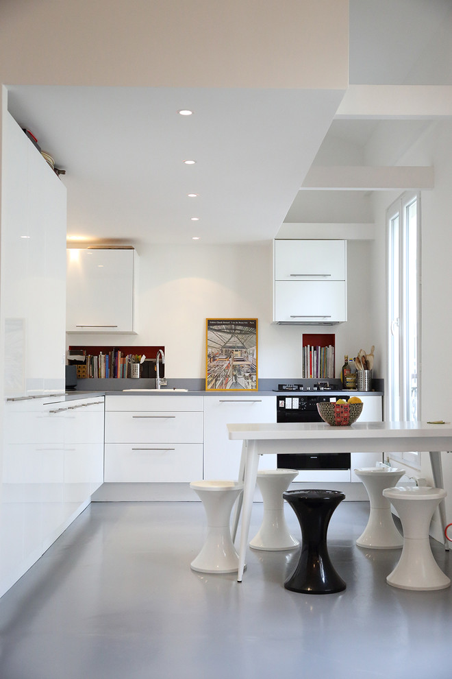 Design ideas for a mid-sized contemporary l-shaped eat-in kitchen in Paris with a drop-in sink, flat-panel cabinets, white cabinets and panelled appliances.