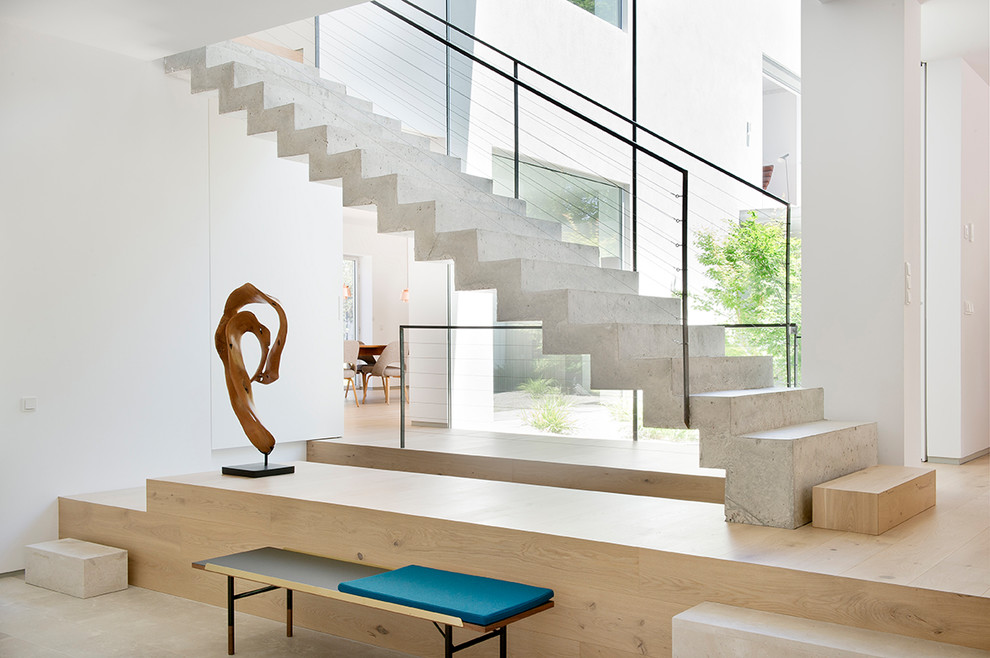 This is an example of a contemporary concrete straight staircase in Madrid with concrete risers and cable railing.