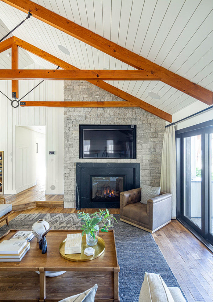 Coburg Farmhouse Remodel - Living room - huge open concept medium tone wood floor, brown floor, exposed beam and wall paneling living room idea with white walls, a standard fireplace, a stone fireplace and a wall-mounted tv