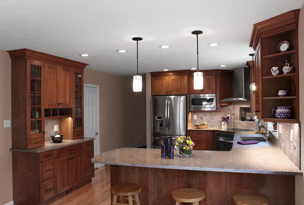 Eat-in kitchen - large transitional u-shaped light wood floor eat-in kitchen idea in Boston with an undermount sink, shaker cabinets, medium tone wood cabinets, quartz countertops, gray backsplash, porcelain backsplash, stainless steel appliances and a peninsula