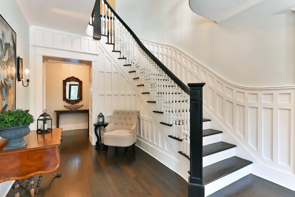 This is an example of a traditional wood curved staircase in New York with wood risers and wood railing.