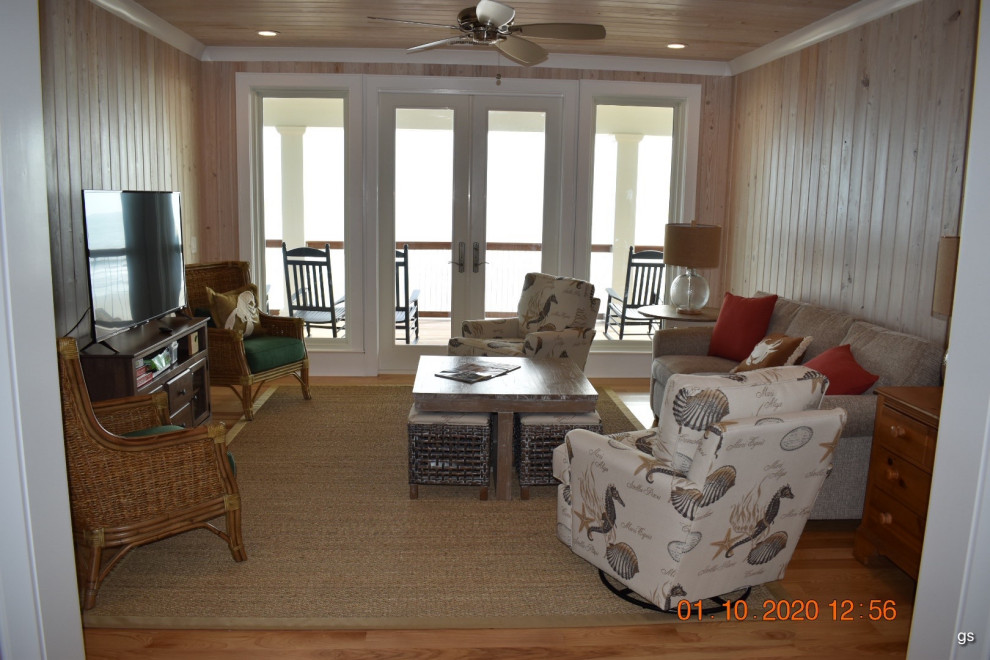 Immagine di un soggiorno stile marinaro di medie dimensioni e chiuso con pavimento in legno massello medio, soffitto in perlinato e pannellatura