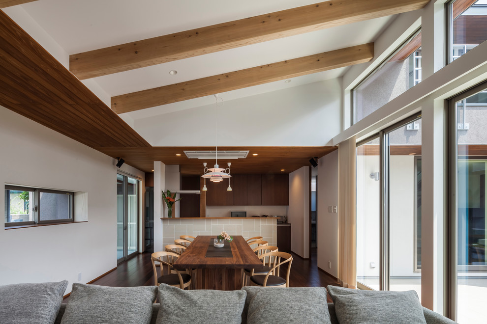 This is an example of a midcentury open plan dining in Other with white walls, dark hardwood floors and brown floor.