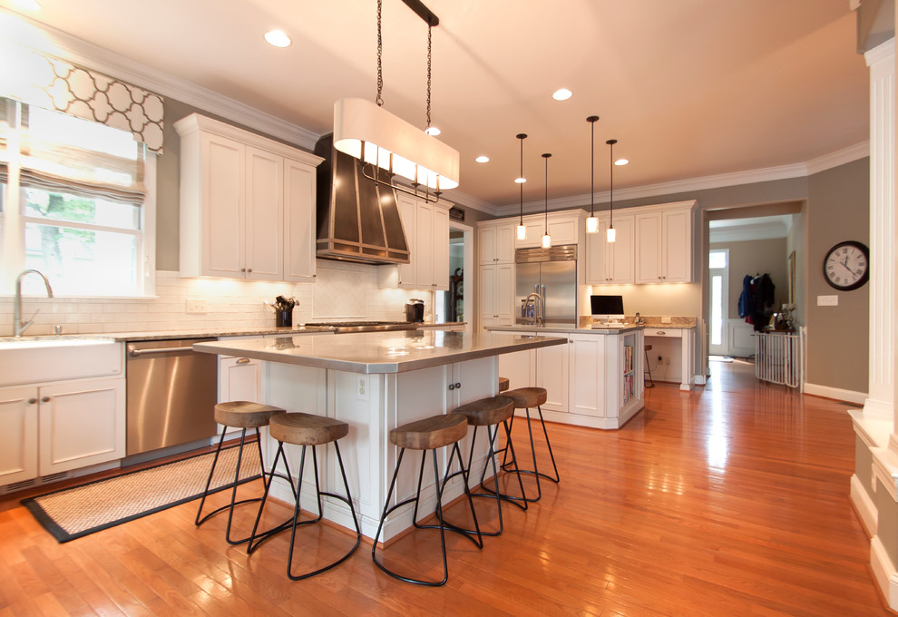 Inspiration for a large transitional medium tone wood floor kitchen remodel in DC Metro with an undermount sink, white cabinets, granite countertops, white backsplash, ceramic backsplash, stainless steel appliances and two islands