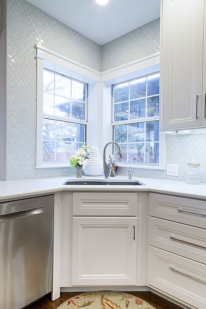 Example of a mid-sized transitional dark wood floor kitchen design in Dallas with a double-bowl sink, recessed-panel cabinets, white cabinets, quartzite countertops, blue backsplash, glass tile backsplash, stainless steel appliances and an island