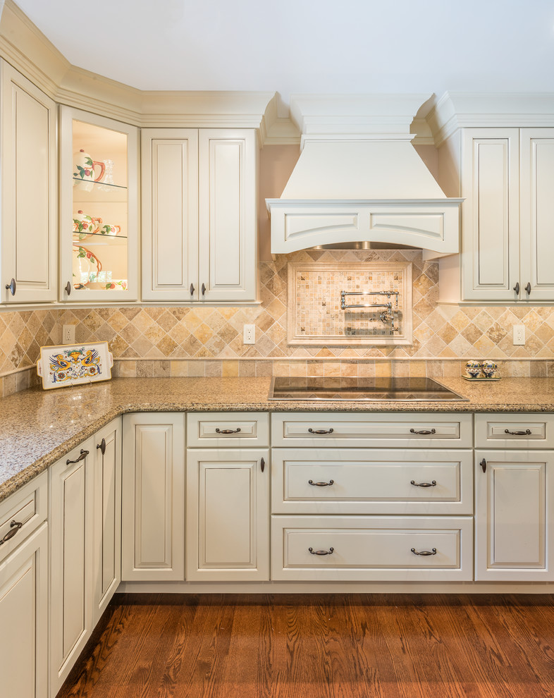 Design ideas for a mid-sized traditional u-shaped eat-in kitchen in Providence with a double-bowl sink, raised-panel cabinets, white cabinets, granite benchtops, beige splashback, ceramic splashback, stainless steel appliances, dark hardwood floors, with island and brown floor.