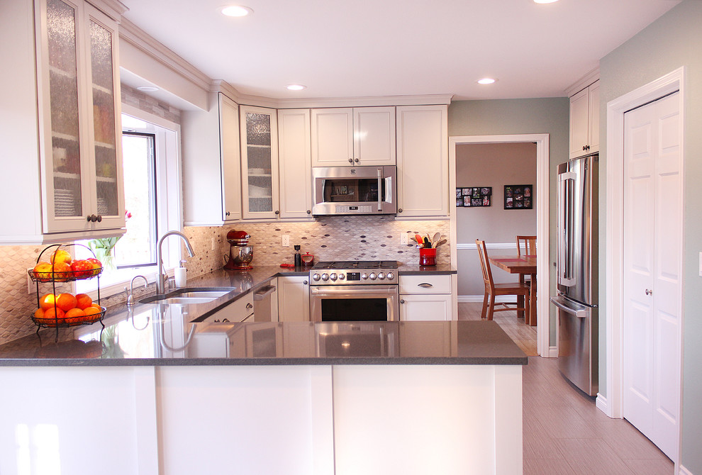 Large transitional u-shaped enclosed kitchen photo with a double-bowl sink, shaker cabinets, white cabinets, granite countertops, multicolored backsplash, stainless steel appliances and a peninsula