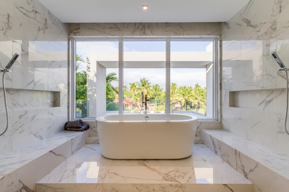 This is an example of a large modern master bathroom in Miami with a freestanding tub, a shower/bathtub combo, white tile, porcelain tile, porcelain floors, white floor and a hinged shower door.