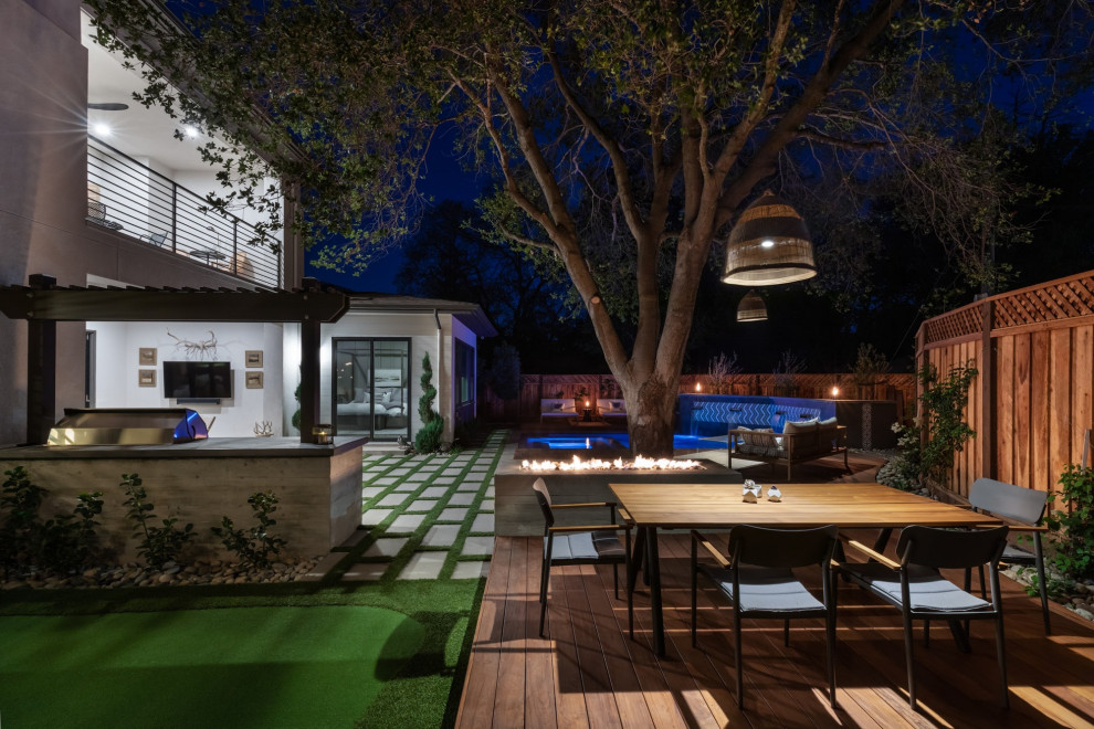 Cette photo montre une terrasse arrière moderne avec un foyer extérieur.