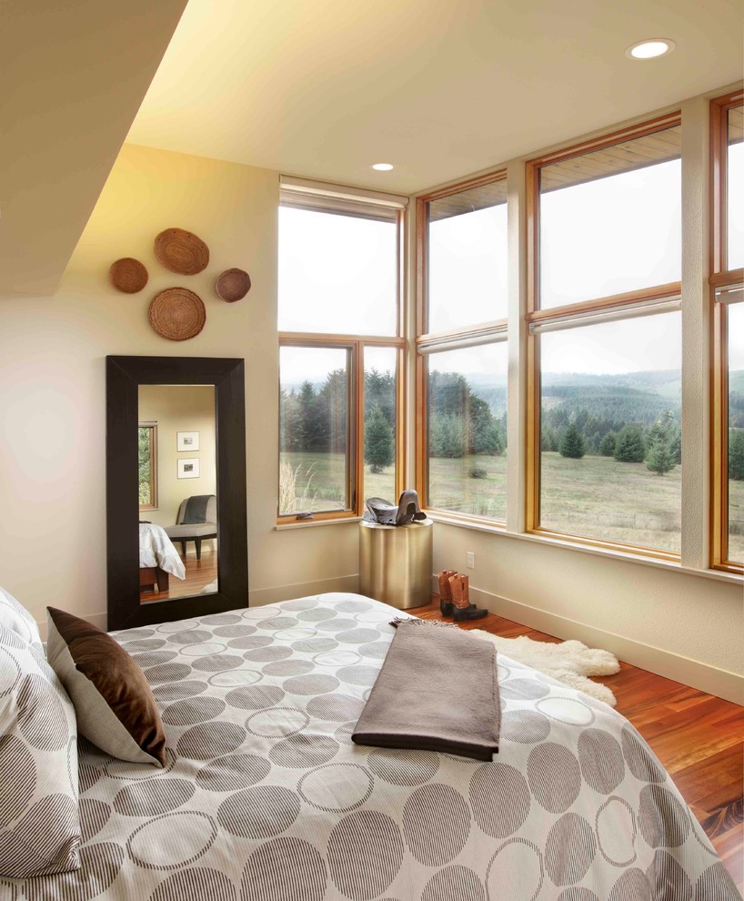 Bedroom - large contemporary master medium tone wood floor bedroom idea in Portland with beige walls