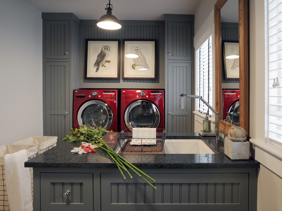 Photo of a large industrial galley utility room in New York with grey cabinets, granite benchtops, grey walls, a side-by-side washer and dryer, shaker cabinets and an undermount sink.