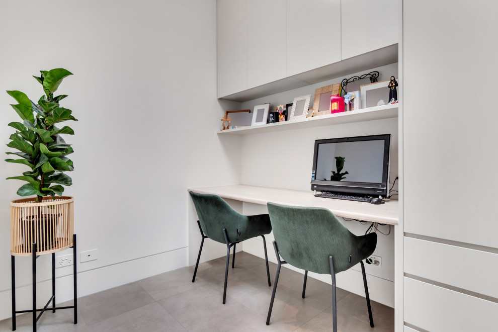 シドニーにある小さなコンテンポラリースタイルのおしゃれなホームオフィス・書斎 (白い壁、造り付け机、グレーの床) の写真
