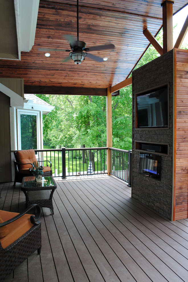 Photo of a large traditional backyard deck in Other with a fire feature and a roof extension.