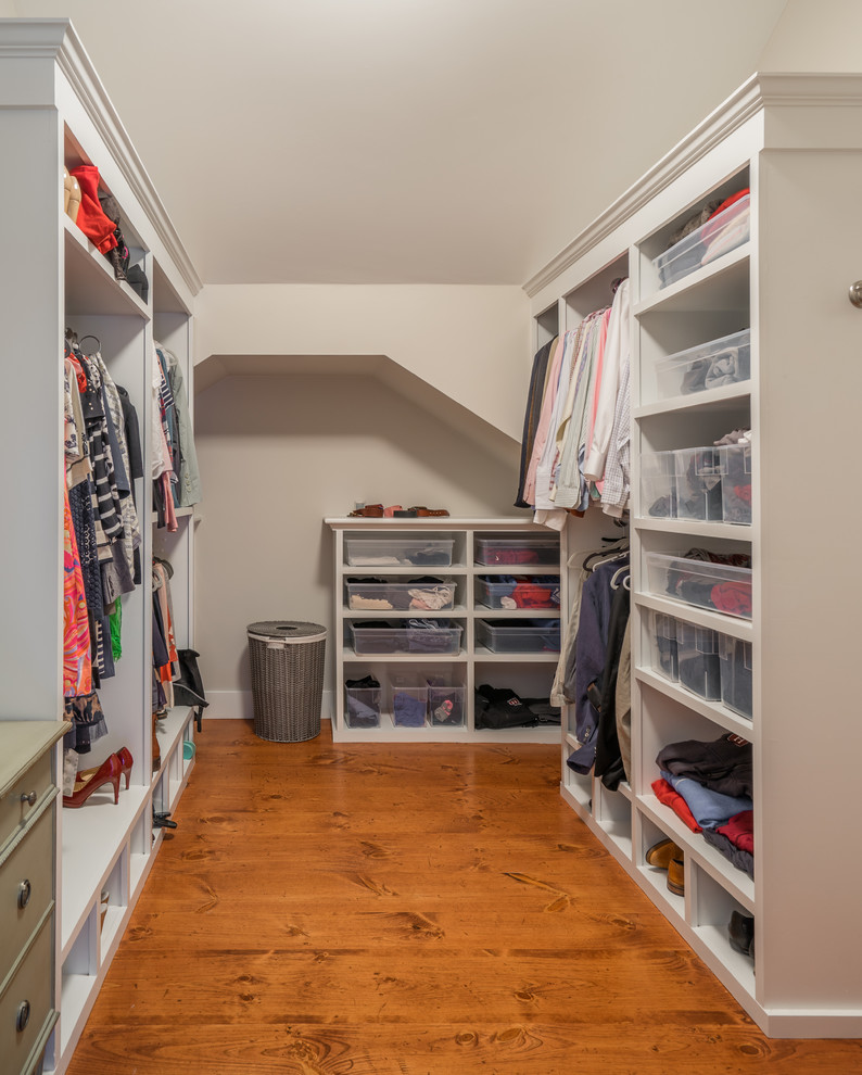 Photo of a large country gender-neutral walk-in wardrobe in Boston with open cabinets, white cabinets and medium hardwood floors.