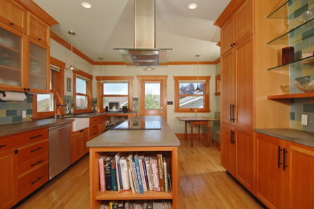 Mid-sized transitional galley medium tone wood floor kitchen pantry photo in Seattle with a farmhouse sink, shaker cabinets, medium tone wood cabinets, wood countertops, multicolored backsplash, glass tile backsplash, stainless steel appliances, gray walls and an island