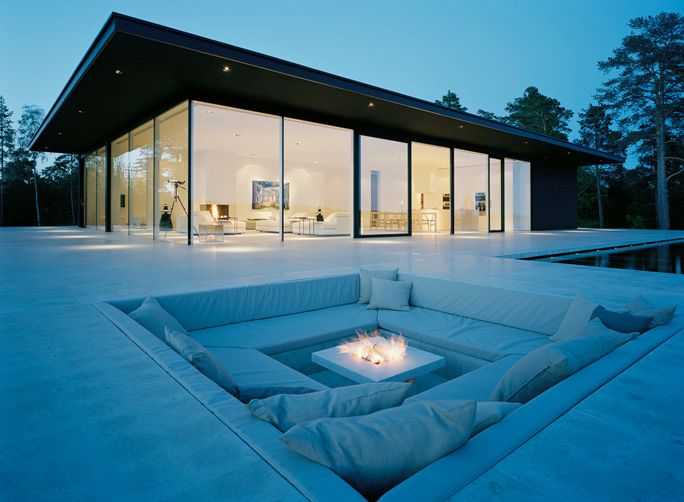 Design ideas for a mid-sized modern backyard patio in Stockholm with a fire feature and no cover.