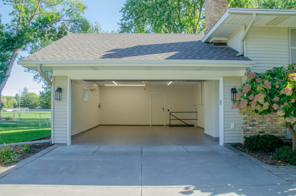 Example of a mid-sized classic attached two-car garage workshop design in Minneapolis