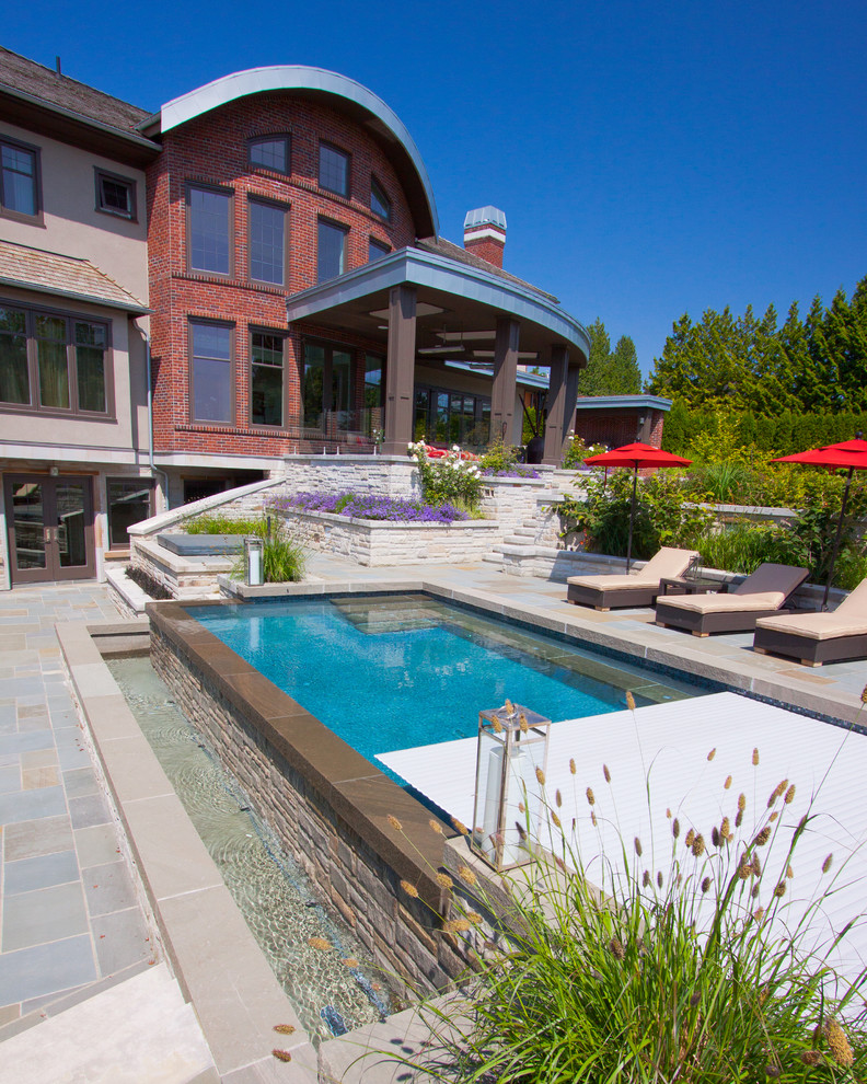 Design ideas for a contemporary side yard rectangular infinity pool in Vancouver with a water feature.