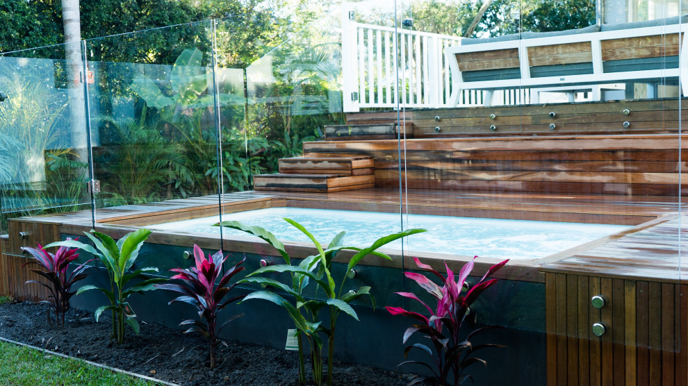 Aménagement d'un petit piscine avec aménagement paysager arrière moderne rectangle avec une terrasse en bois.