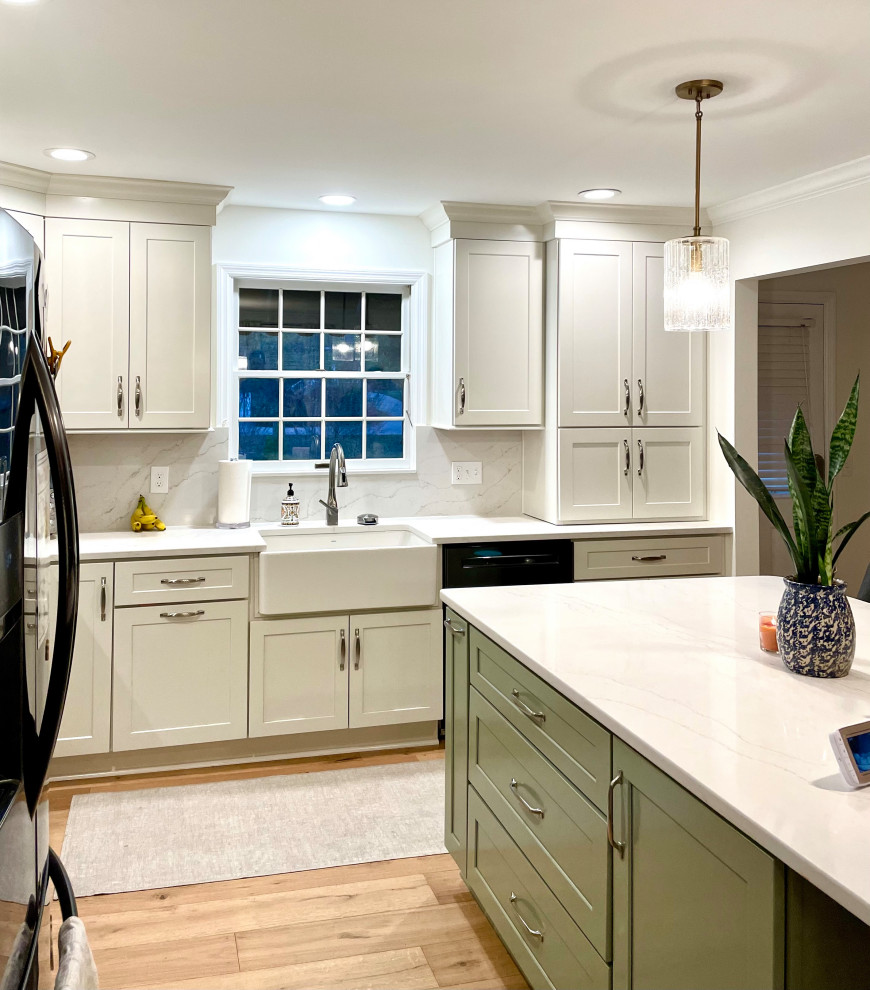 Transitional l-shaped light wood floor and beige floor eat-in kitchen photo with a farmhouse sink, shaker cabinets, white cabinets, quartz countertops, white backsplash, quartz backsplash, black appliances, an island and white countertops
