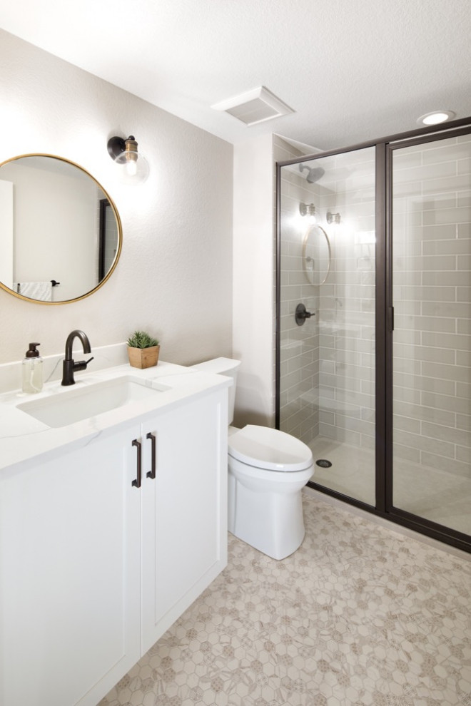 Photo of a mid-sized contemporary 3/4 wet room bathroom in Denver with recessed-panel cabinets, white cabinets, a one-piece toilet, gray tile, ceramic tile, white walls, ceramic floors, a drop-in sink, engineered quartz benchtops, beige floor, a hinged shower door and white benchtops.