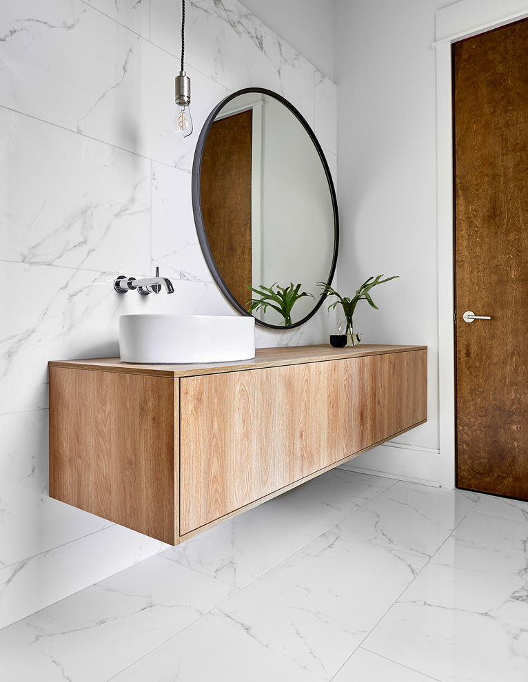 Large contemporary powder room in Charlotte with flat-panel cabinets, light wood cabinets, white tile, marble, white walls, marble floors, a vessel sink, wood benchtops, white floor and beige benchtops.
