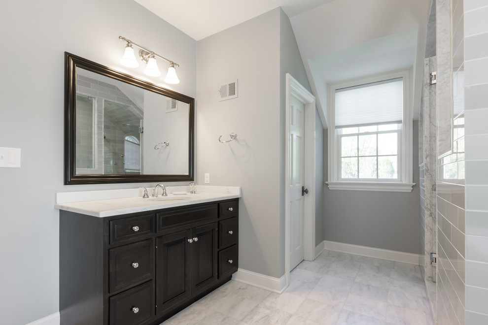 Inspiration for a large transitional master bathroom in Other with shaker cabinets, dark wood cabinets, a freestanding tub, grey walls, marble floors, a console sink, quartzite benchtops, white floor, a hinged shower door and white benchtops.