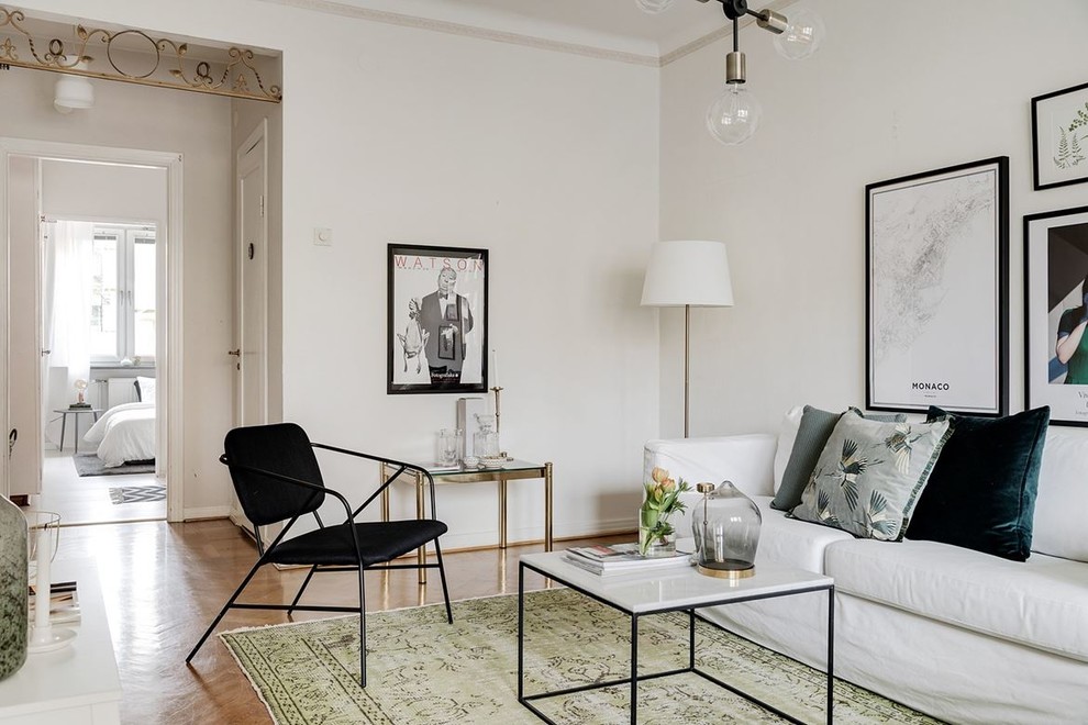 Photo of a scandinavian living room in Malmo with white walls, medium hardwood floors and brown floor.