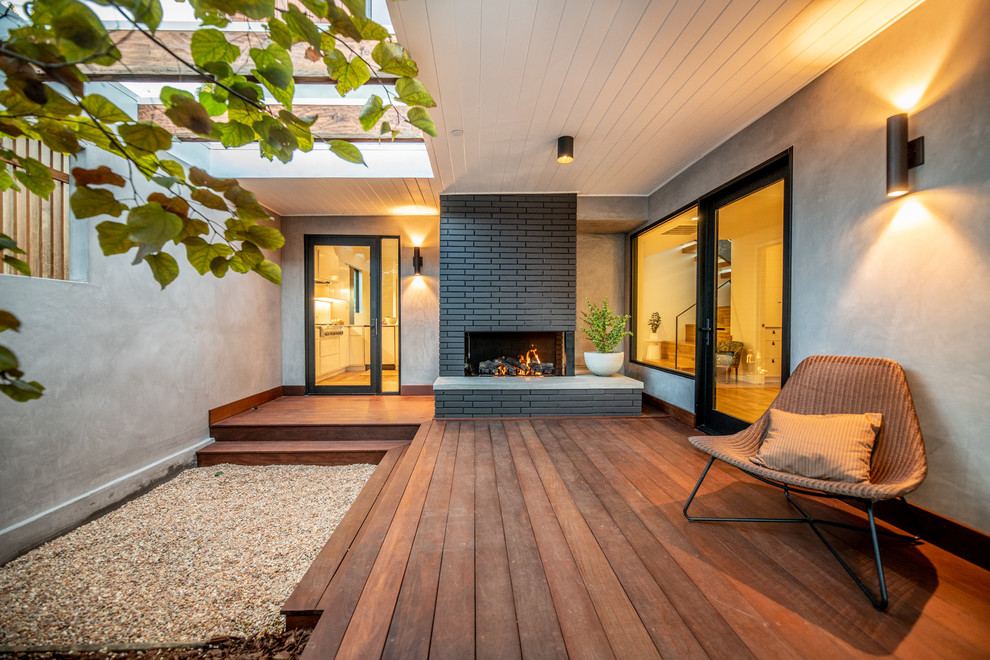 This is an example of a mid-sized contemporary deck in Los Angeles with a roof extension.