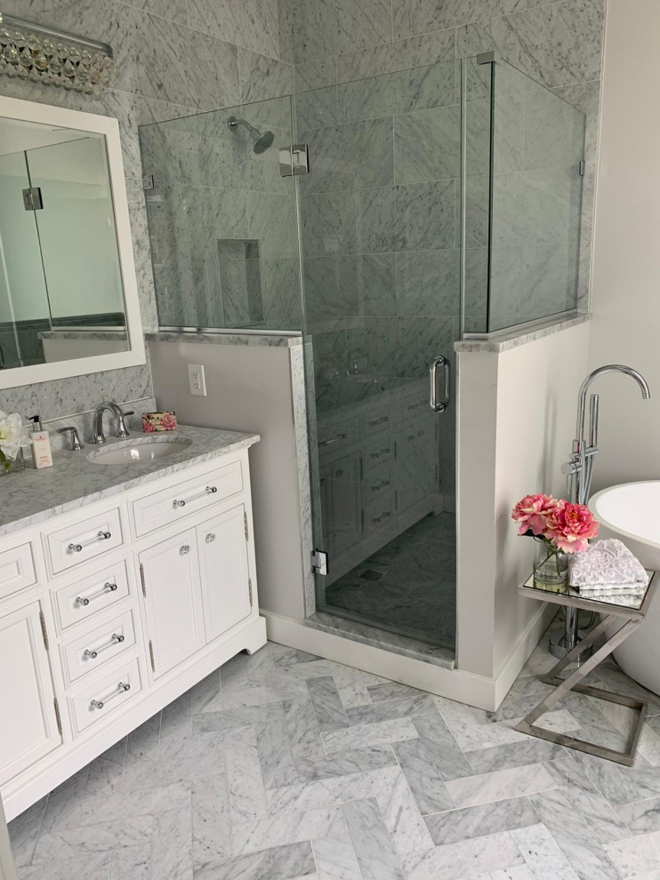 This is an example of a large traditional master bathroom in New York with beaded inset cabinets, white cabinets, a freestanding tub, a corner shower, a one-piece toilet, gray tile, marble, grey walls, marble floors, a drop-in sink, granite benchtops, grey floor, an open shower, grey benchtops, a double vanity and a freestanding vanity.
