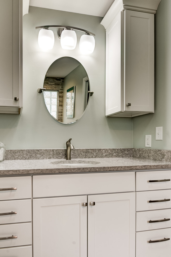 Inspiration for a mid-sized transitional master gray tile and porcelain tile porcelain tile and gray floor drop-in bathtub remodel in Chicago with recessed-panel cabinets, white cabinets, a two-piece toilet, blue walls, an undermount sink, solid surface countertops and a hinged shower door