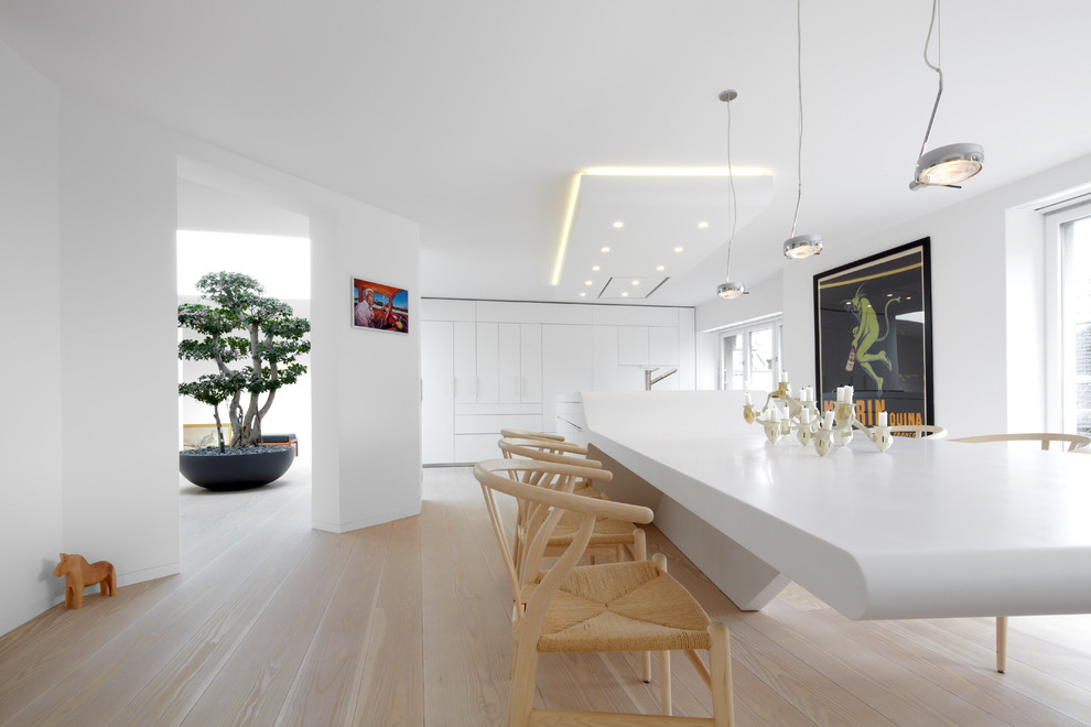 Large contemporary open plan dining in Frankfurt with white walls and light hardwood floors.