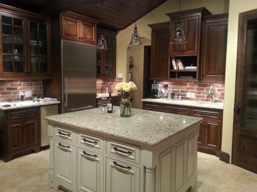Example of a large mountain style u-shaped porcelain tile eat-in kitchen design in Houston with an undermount sink, raised-panel cabinets, dark wood cabinets, granite countertops, red backsplash, brick backsplash, stainless steel appliances and two islands