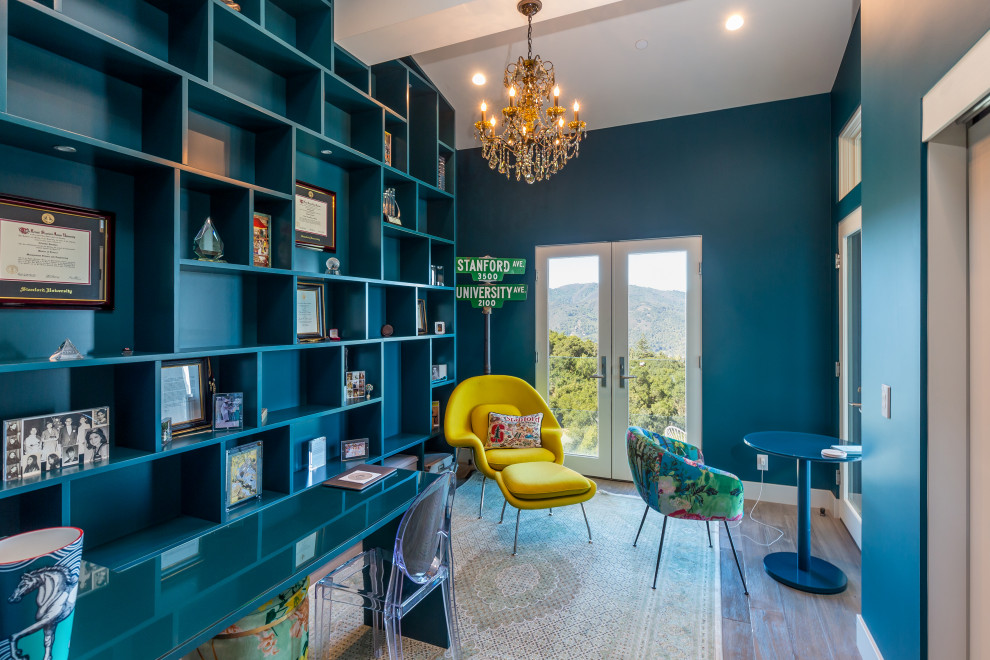 Photo of a mid-sized mediterranean home office in San Francisco with a library, blue walls and a freestanding desk.