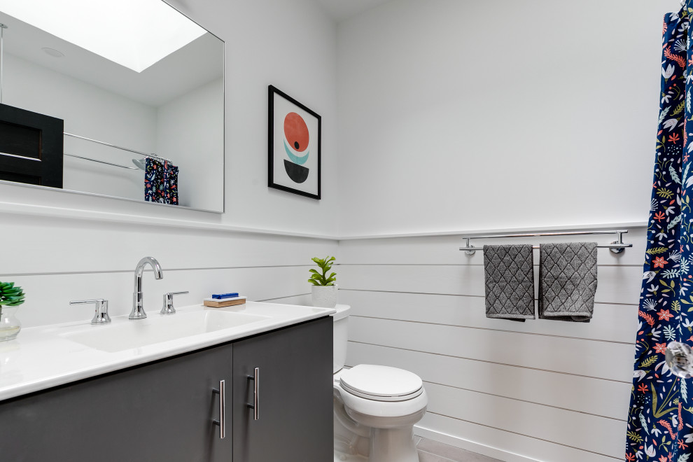 Inredning av ett klassiskt mellanstort en-suite badrum, med släta luckor, en kantlös dusch, vit kakel, keramikplattor, ljust trägolv, bänkskiva i kvarts och dusch med skjutdörr