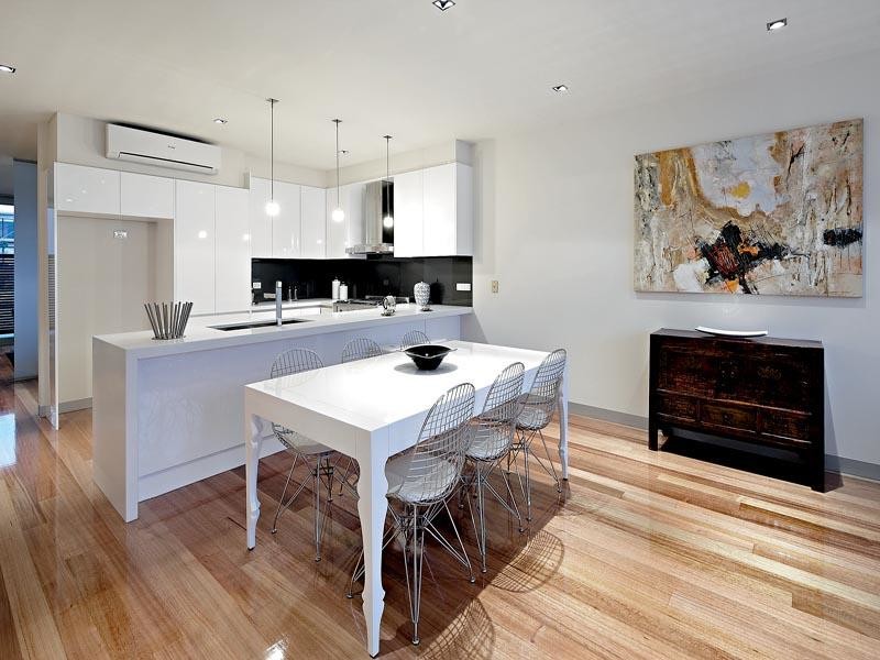 Design ideas for a large modern u-shaped open plan kitchen in Melbourne with an undermount sink, glass-front cabinets, white cabinets, glass benchtops, grey splashback, glass tile splashback, stainless steel appliances and light hardwood floors.