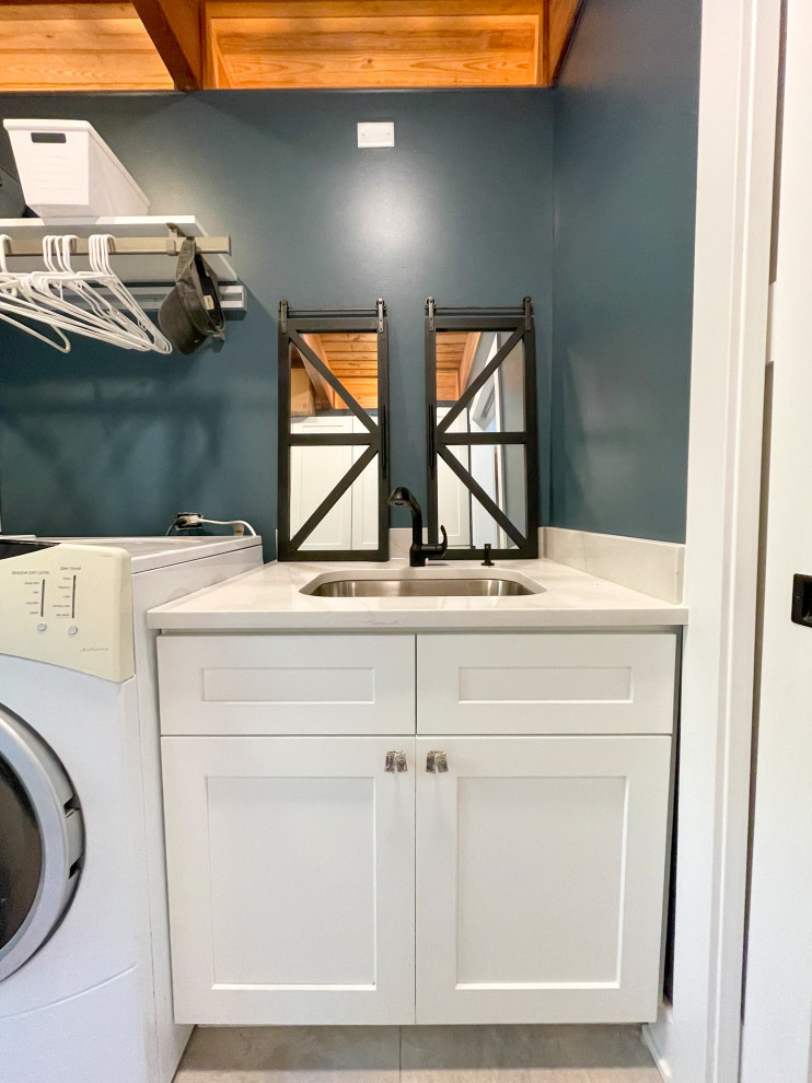 シカゴにある高級な中くらいなトラディショナルスタイルのおしゃれな洗濯室 (ll型、アンダーカウンターシンク、シェーカースタイル扉のキャビネット、白いキャビネット、クオーツストーンカウンター、白いキッチンパネル、クオーツストーンのキッチンパネル、青い壁、セラミックタイルの床、左右配置の洗濯機・乾燥機、ベージュの床、白いキッチンカウンター、板張り天井) の写真
