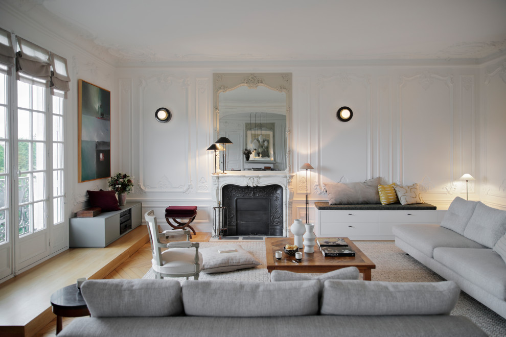 Immagine di un soggiorno minimal con pareti bianche, parquet chiaro, camino classico, cornice del camino in pietra e pavimento beige
