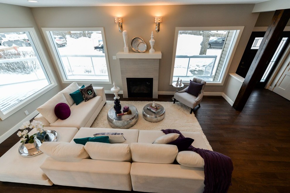 Mid-sized contemporary formal open concept living room in Calgary with beige walls, dark hardwood floors, a standard fireplace, a tile fireplace surround, no tv and brown floor.