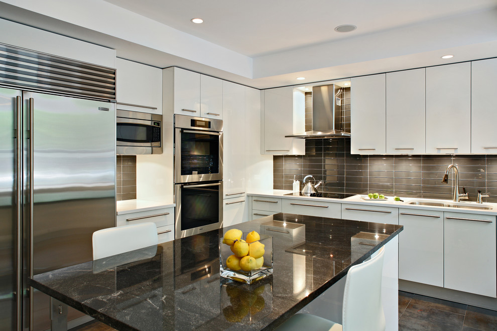 Large contemporary u-shaped eat-in kitchen in New York with a double-bowl sink, flat-panel cabinets, white cabinets, brown splashback, glass tile splashback, stainless steel appliances, with island and ceramic floors.