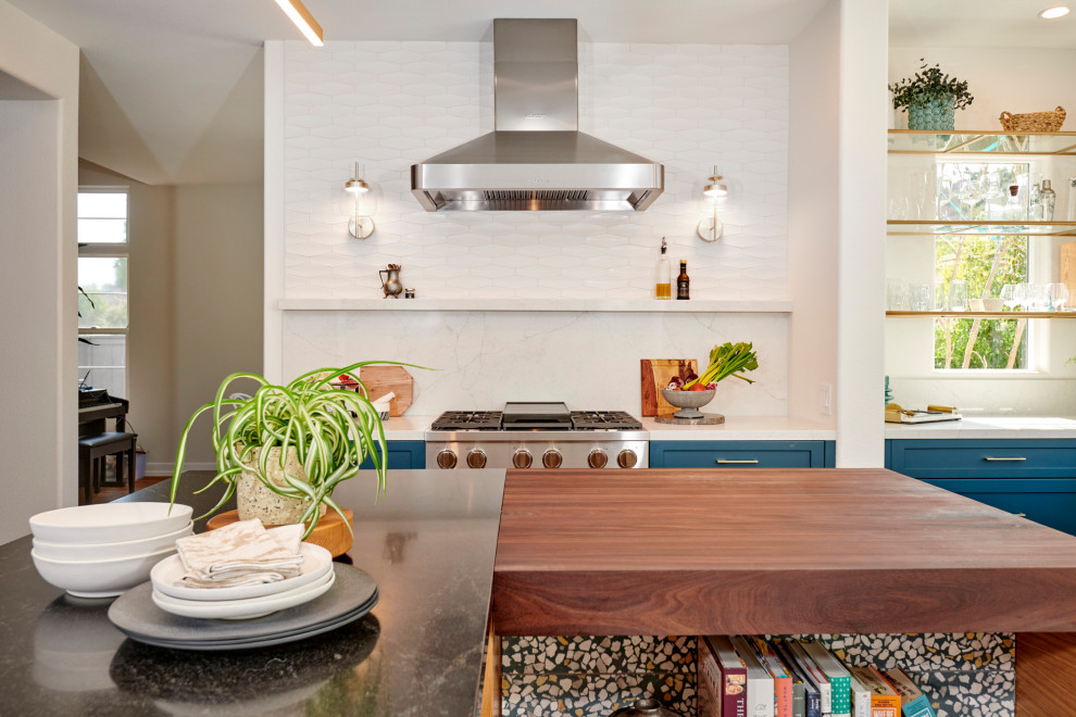 Foto på ett stort 50 tals vit kök, med en undermonterad diskho, luckor med infälld panel, gröna skåp, bänkskiva i kvarts, vitt stänkskydd, stänkskydd i keramik, rostfria vitvaror, klinkergolv i porslin, en köksö och grått golv